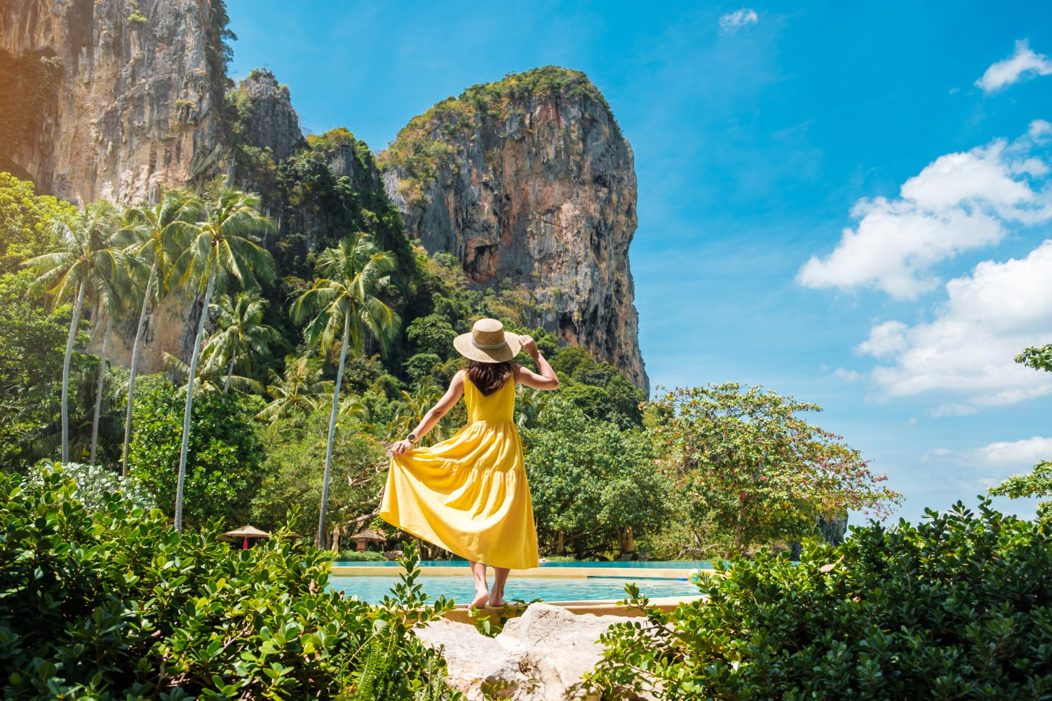 Woman tourist in yellow dress and hat traveling on Railay .jpg